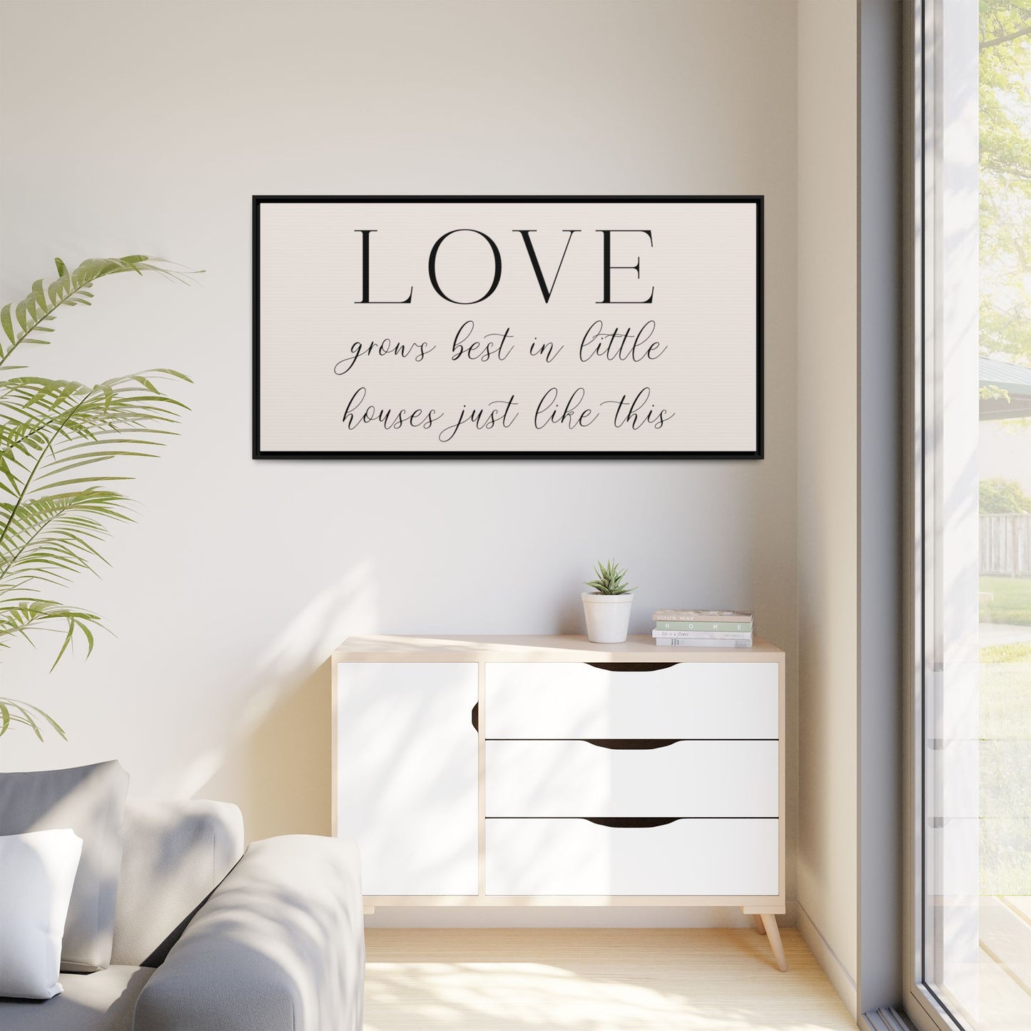 Modern living room with a 'LOVE' framed wall quote, white sofa, and decorative items front view