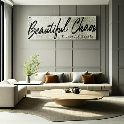 Modern minimal living room with a customized textured 'Beautiful Chaos' last name family sign on the wall.